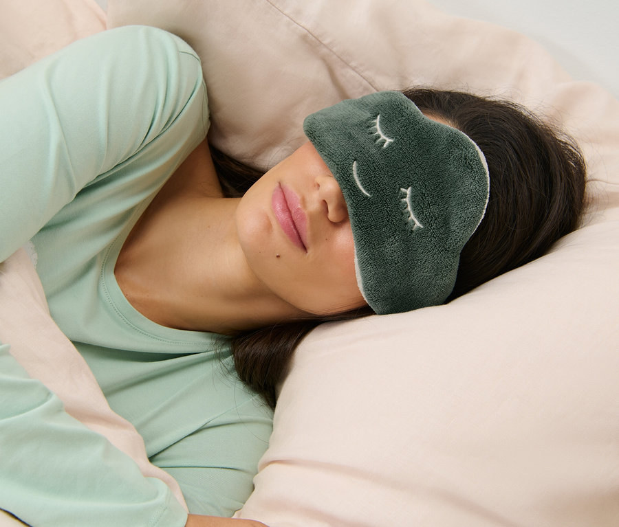 Frau schläft mit Schlafmaske Wolke auf den Augen.