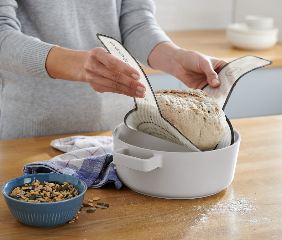 Frau legt Brot mit einer Dauerbackmatte in eine Schüssel.