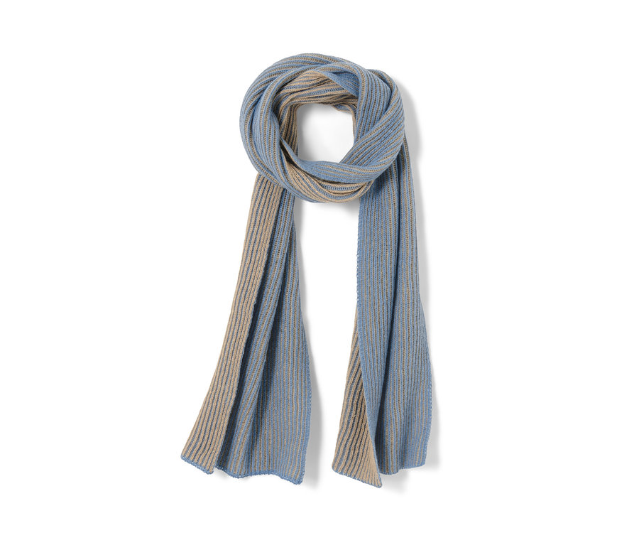 Ein Strickschal ist zu einer Schlaufe gedreht und hängt herunter. Der Schal ist hellblau und beige.