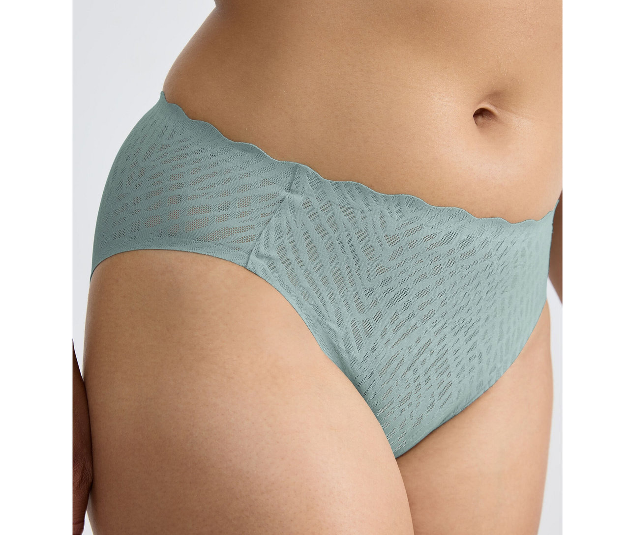 Hüfte einer Person, die einen sloggi ZERO Feel Bliss High leg Slip in Misty Turquoise mit Wellenkante und dezentem Muster trägt.
