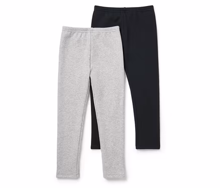 Zwei Leggings, eine graue und eine schwarze, liegen nebeneinander auf einem weißen Hintergrund.