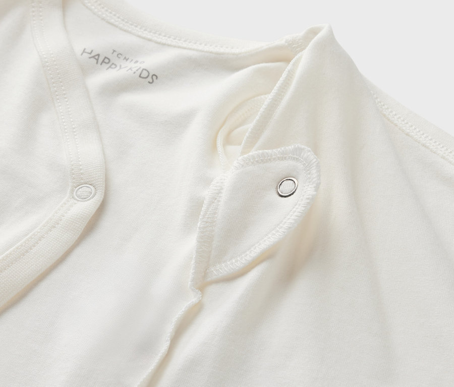 Detailansicht eines weißen 5 Baby-Bodys mit Mitwachsfunktion und Druckknopf.