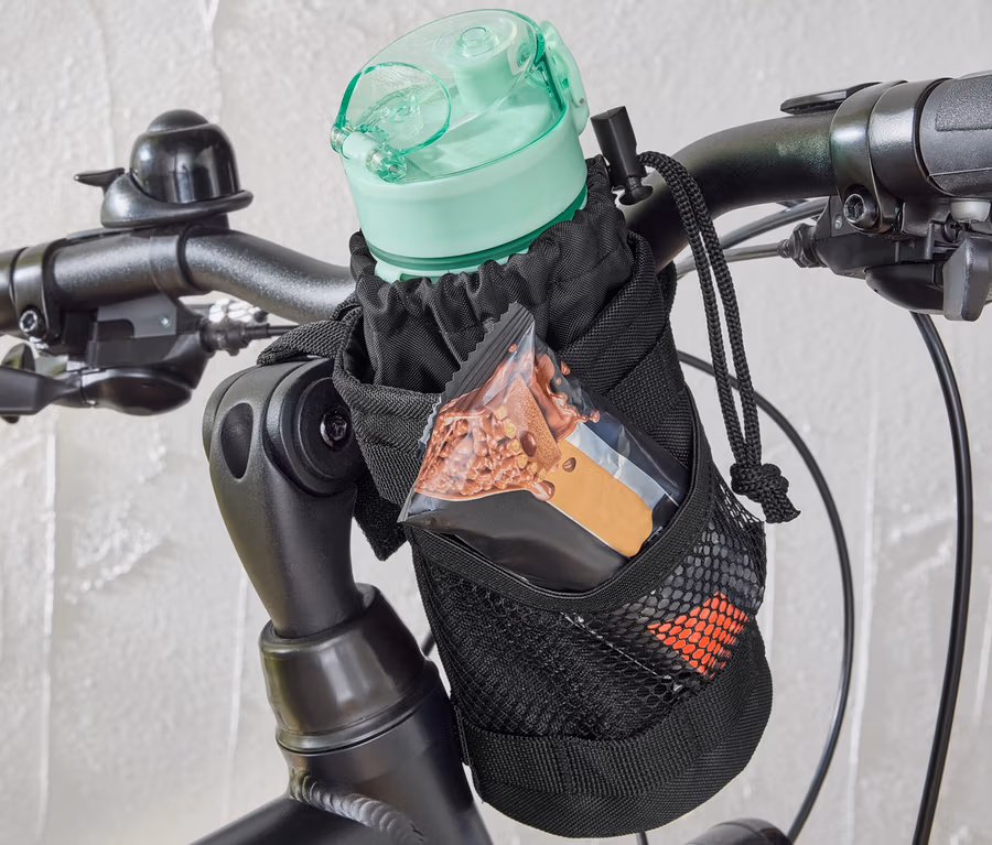 Eine Fahrrad-Snacktasche ist am Lenker eines Fahrrads befestigt, die eine Wasserflasche und einen Müsliriegel enthält.