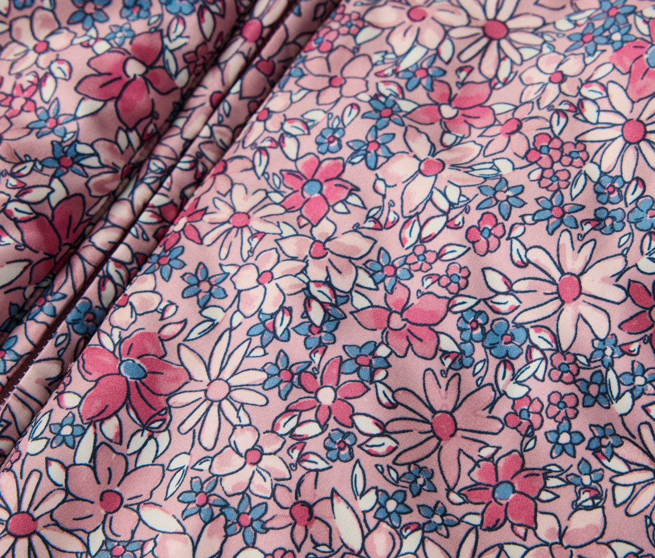 Detailansicht eines Baby-Winteroveralls mit Blumenmuster.