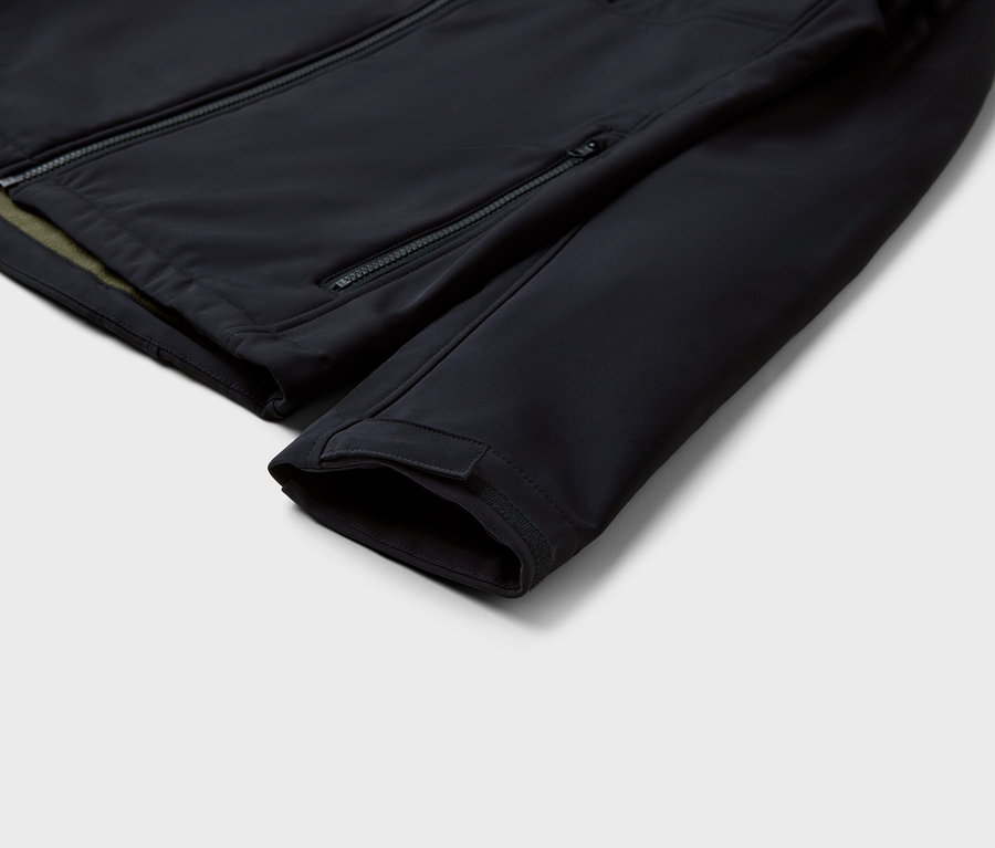 Detailaufnahme einer schwarzen Jacke mit Reißverschlüssen und Ärmel.