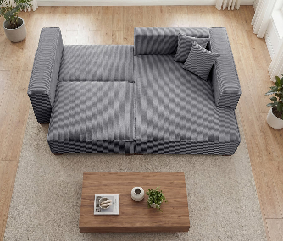 Blick von oben auf ein anthrazitfarbenes »Cumello« Sofa 2-Sitzer mit Auszugsbett links und Longchair rechts im Raum.