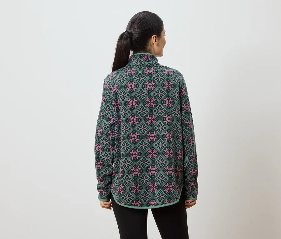 Rückansicht einer Frau mit Pferdeschwanz, die ein grün-rosa gemustertes Fleece-Oberteil und schwarze Leggings vor einem weißen Hintergrund trägt.