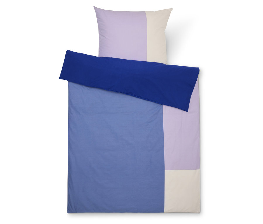 Draufsicht eines farblich blockierten Bettbezugssets mit blauem Bettlaken, lavendelfarbenem und cremefarbenem Kissenbezug.