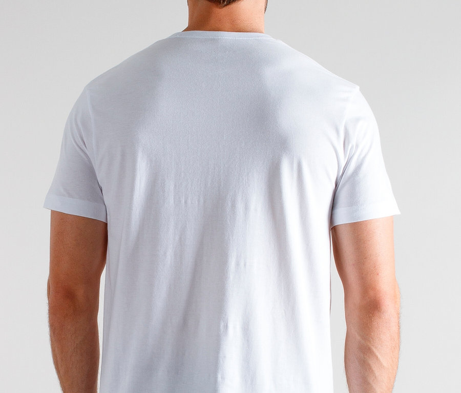 Rückansicht eines Mannes mit weißem T-Shirt und karierter Pyjamahose vor einem neutralen Hintergrund.