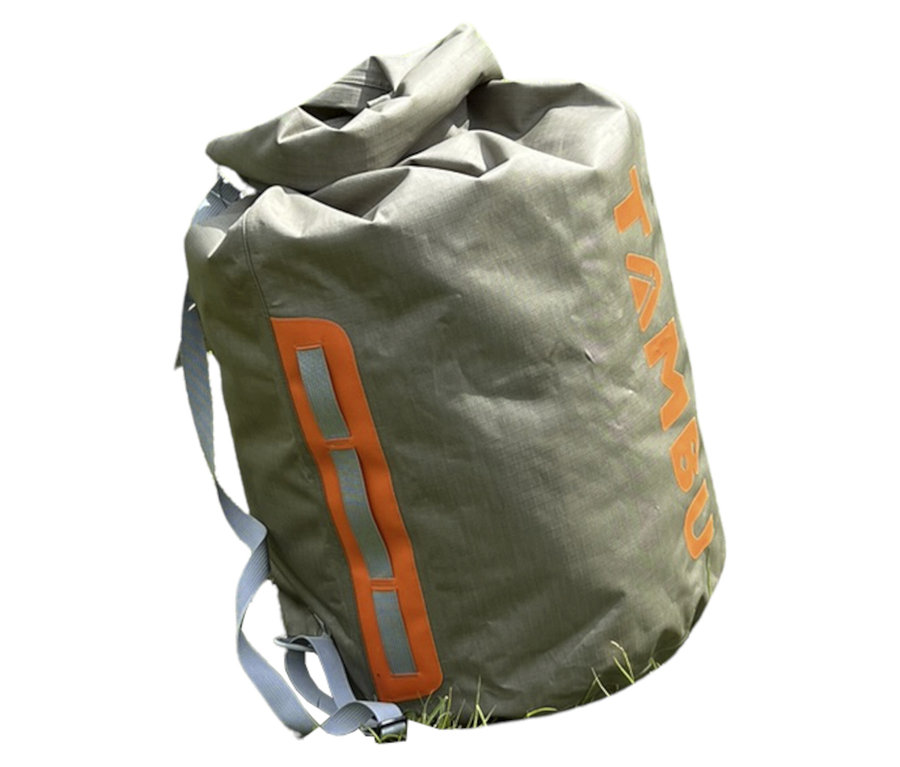 Der Tambu Wasserdichter Packsack »JOLA 80« in Khaki steht auf Gras. Er hat orangefarbene Details und graue Träger.