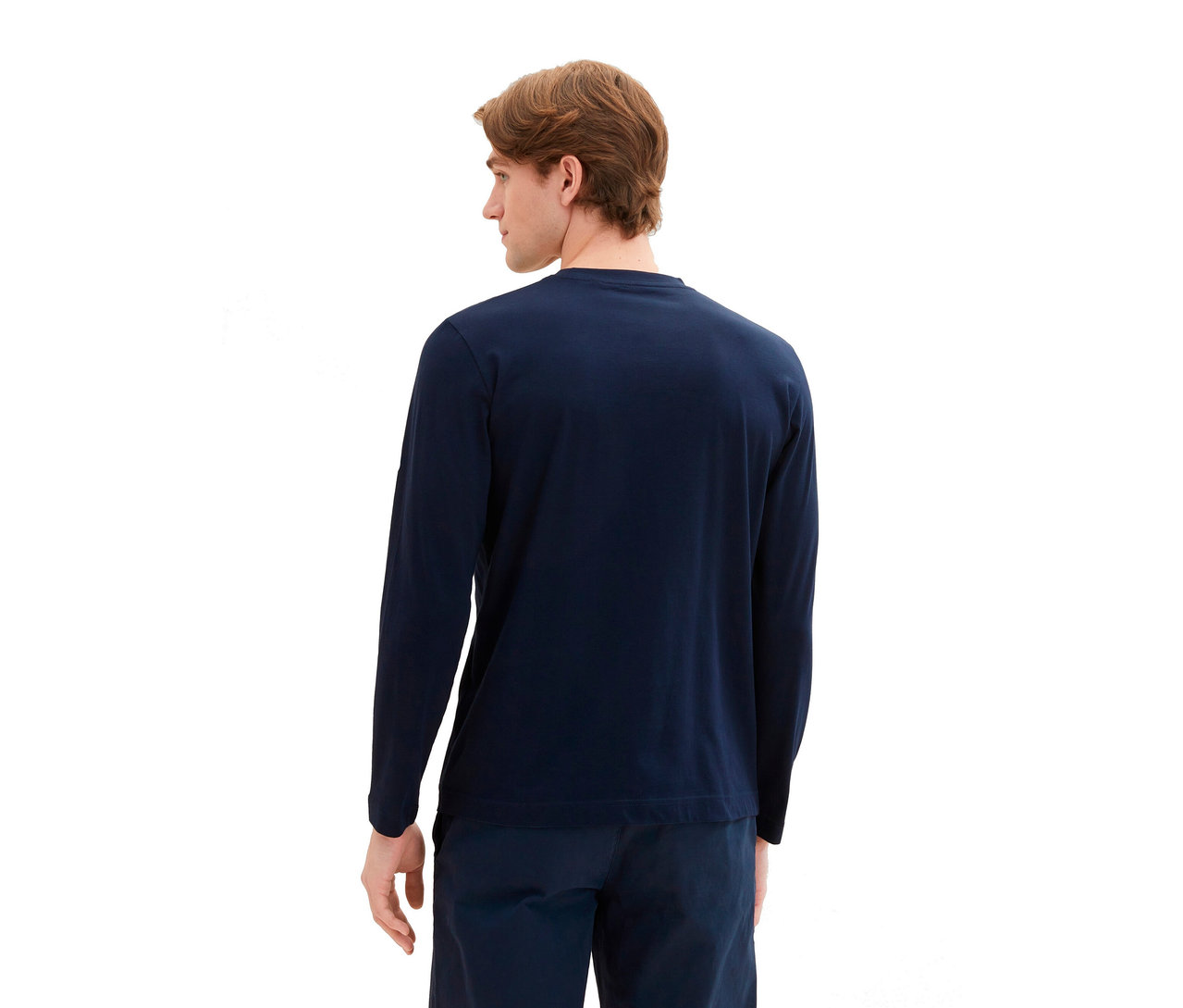 Mann von hinten, trägt ein Tom Tailor Longsleeve mit Logo in Sky Captain Blue und passende Hose.