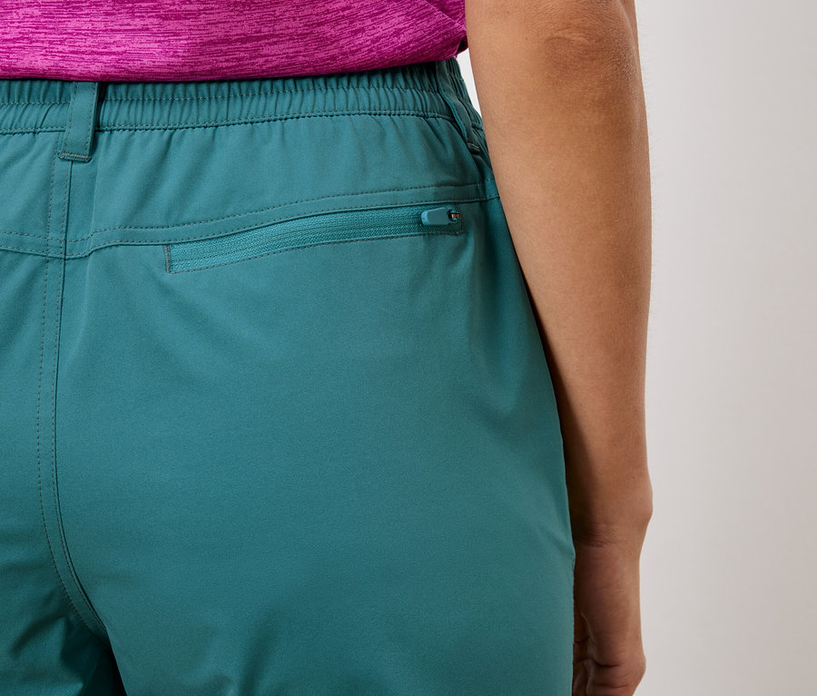 Nahaufnahme der Rückseite einer türkisfarbenen Hose mit elastischem Bund und Reißverschlusstasche.