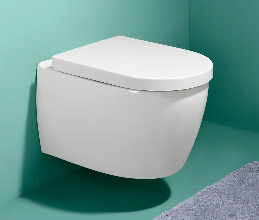 Weiße Toilette mit Premium-WC-Sitz mit Absenkautomatik an einer blaugrünen Wand.