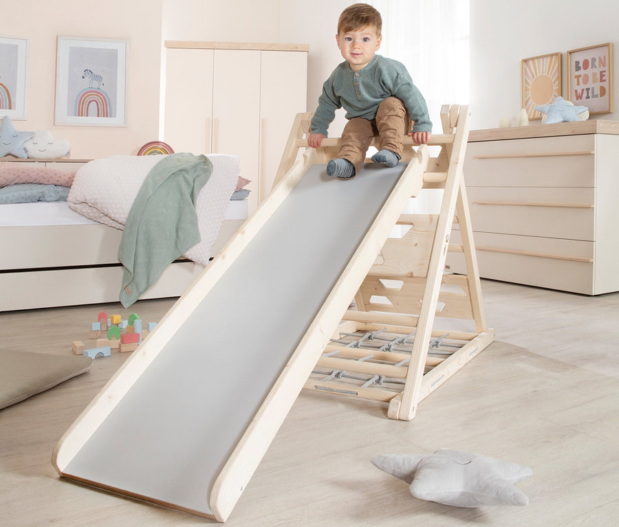 Junge benutzt roba Rutschbrett im Kinderzimmer.