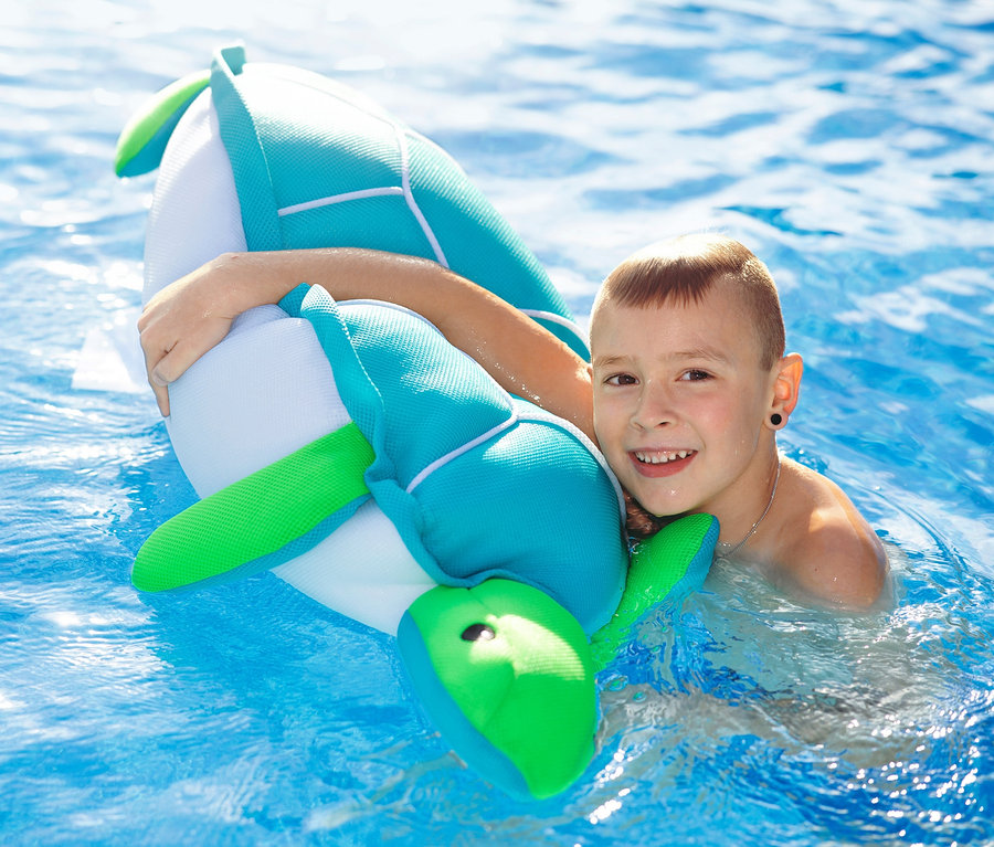 Junge umarmt Pool Buddy Schildkröte im Pool.