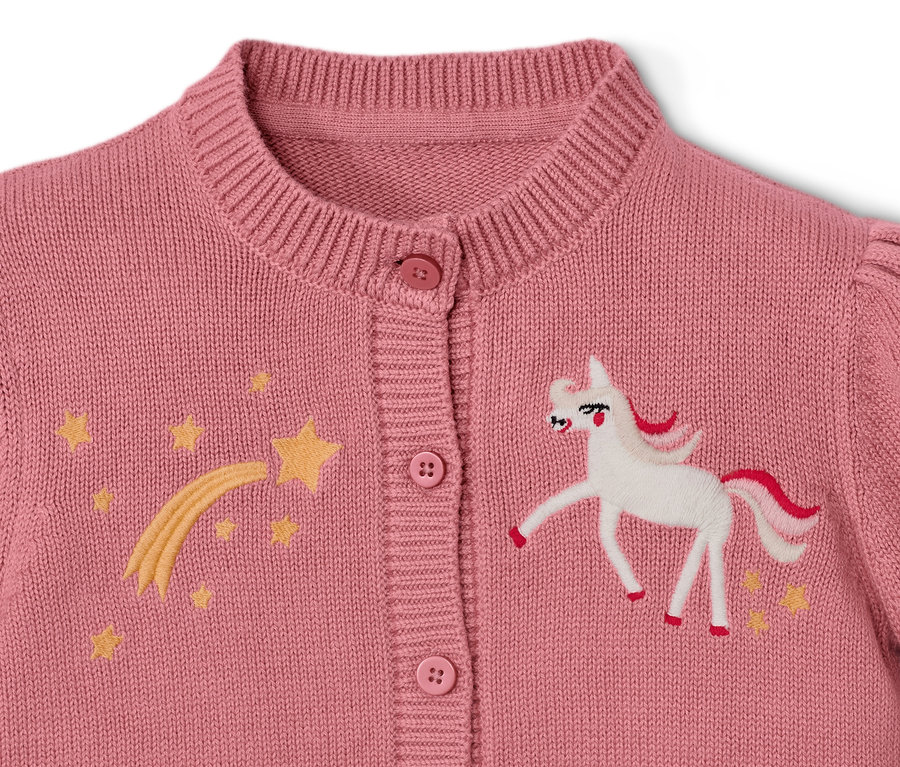 Detailansicht einer Kinder-Strickjacke mit Einhorn und Sternen.