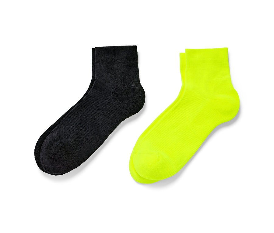 Zwei Paar kurze Sportsocken, ein Paar schwarz und ein Paar neon gelb.