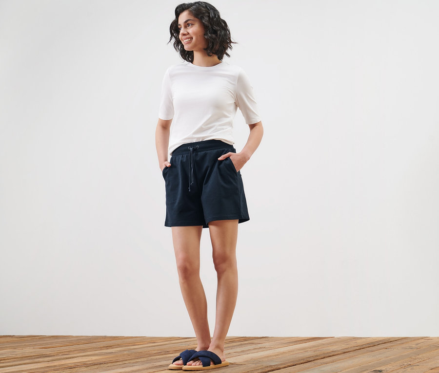 Frau posiert in Sweatshorts und T-Shirt.