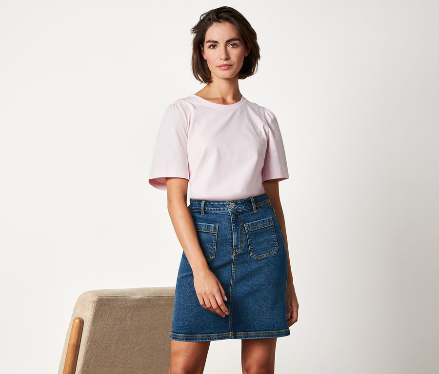 Frau posiert in Jeansrock.