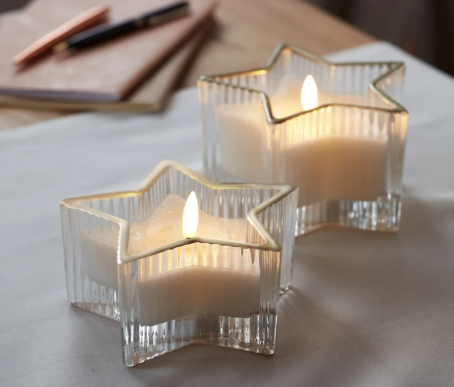 Zwei LED-Echtwachskerzen im Glas in Sternform.