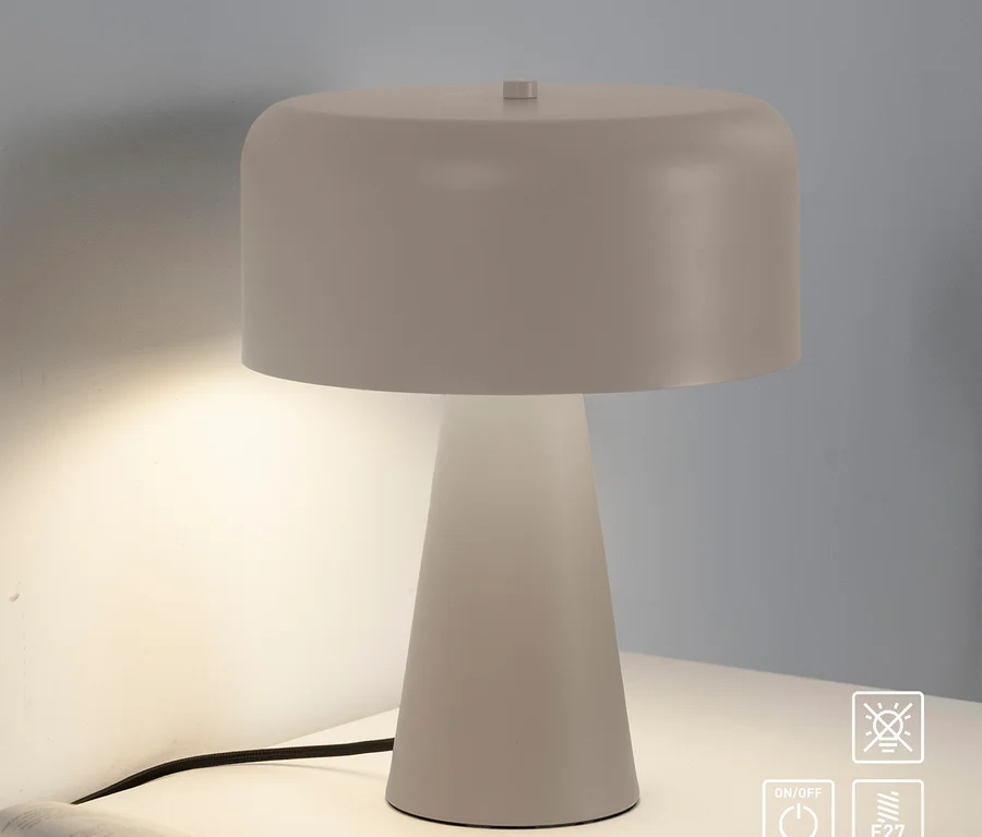Weiße Tischlampe leuchtet auf einem weißen Nachttisch neben einem offenen Buch.