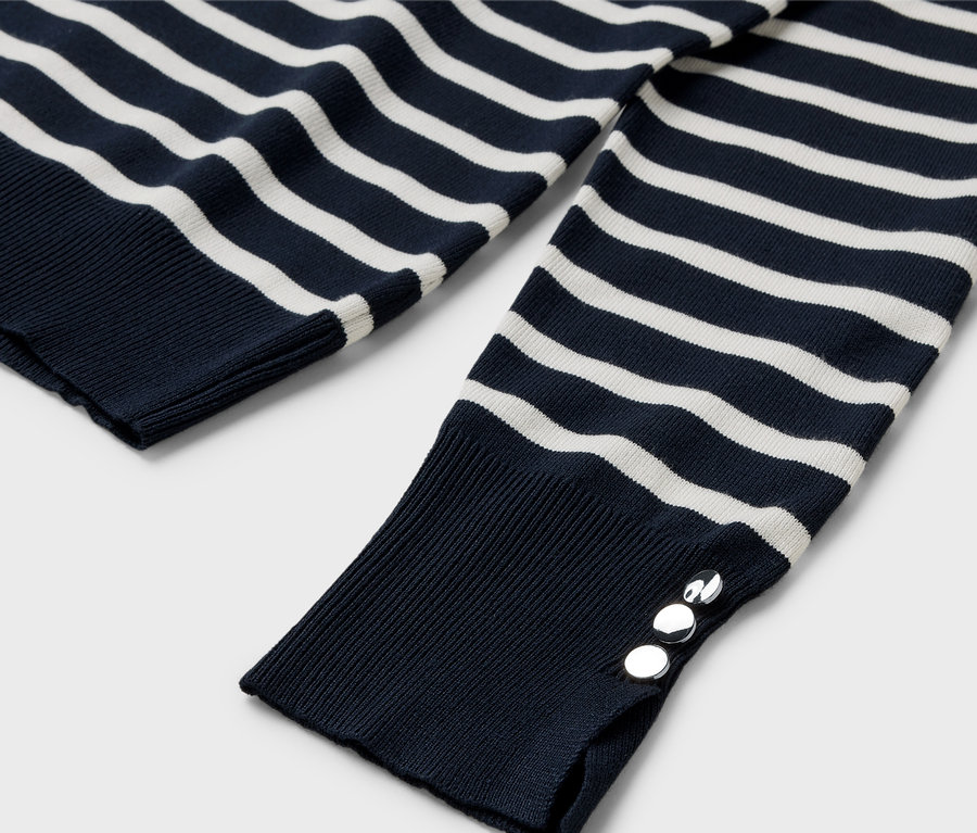 Detailansicht eines blau-weiß gestreiften Langarmpullovers mit silbernen Knöpfen an der Manschette.