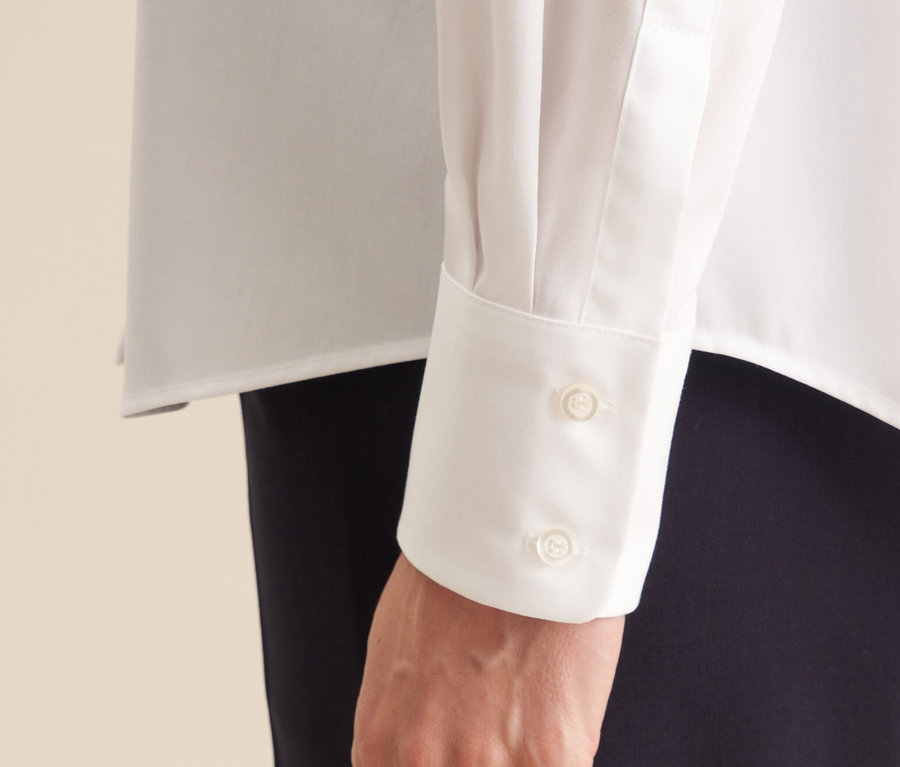 Detail einer Hand in einer Seidensticker bügelfreien Bluse, mit zwei Knöpfen an der Manschette.