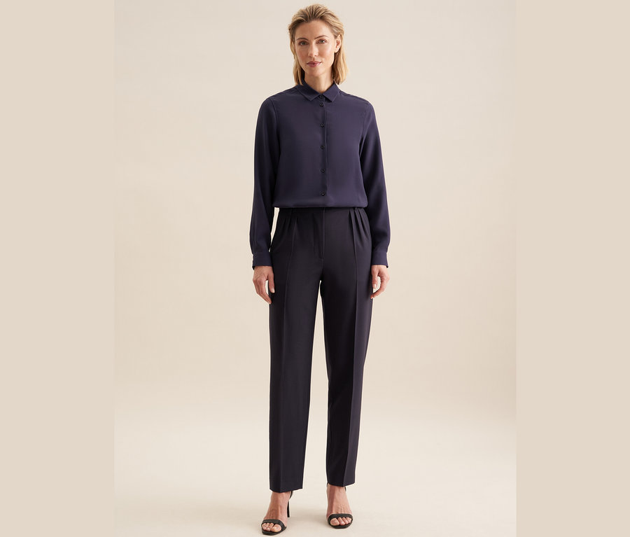 Frau trägt eine Seidensticker Bluse aus Viskose und Hose.