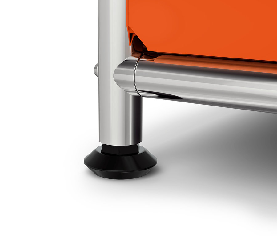 Detailaufnahme eines orangefarbenen Schranks mit verchromtem Bein und schwarzem Fuß.