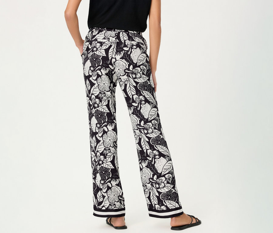 Frau von hinten mit Olsen Wide Leg Hose mit Blumenmuster und schwarzen Sandalen.