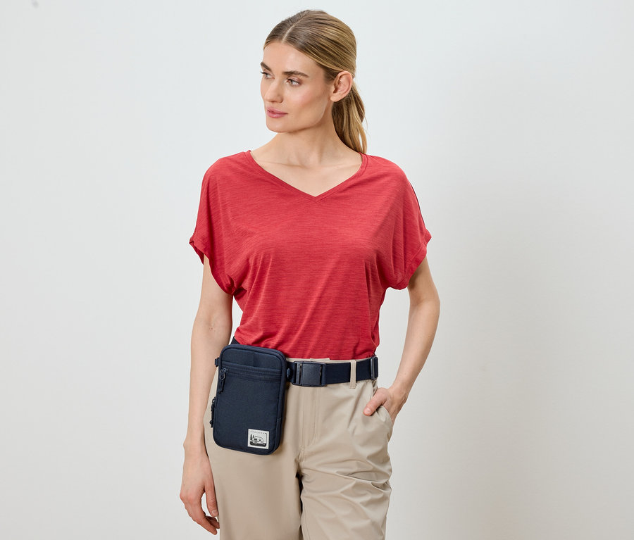 Frau trägt rotes T-Shirt, Khakihose und eine blaue Gürteltasche.