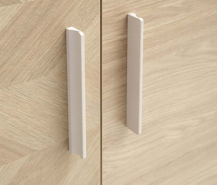 Nahaufnahme von einem hellbraunen Holzschrank mit zwei Türen und weißen, vertikalen Griffen.