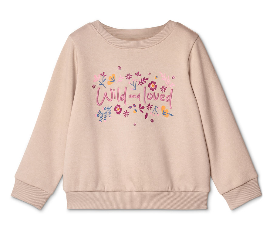 Ein beiger Pullover mit der Aufschrift "Wild and loved" und Blumenmotiven ist auf einem weißen Hintergrund zu sehen.