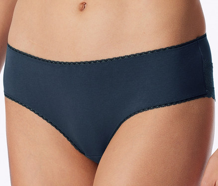 Nahaufnahme einer Person, die dunkelblaue Slips mit zarter dunkler Spitzenborte an Taille und Beinöffnungen sowie einem Spitzendetail an der Hüfte trägt.