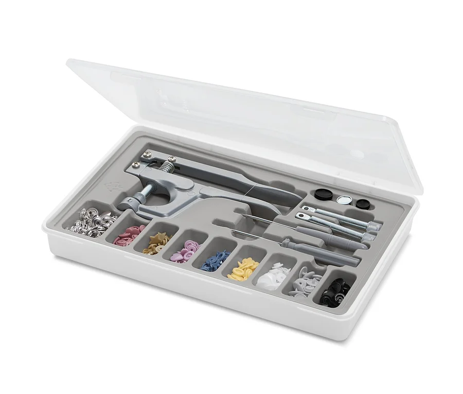 Druckknopf-Set in weißer Plastikbox mit transparentem Deckel.
