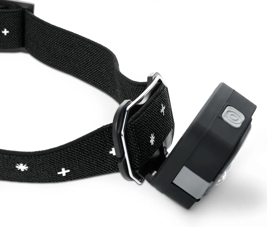 Nahaufnahme einer schwarzen LED-Stirnlampe mit einem Muster aus weißen Schneeflocken und Kreuzen auf dem Band.