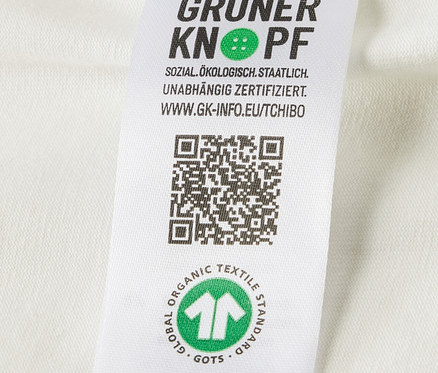 Detailansicht eines Etiketts mit Logo und Bio-Baumwoll-Zertifizierung auf 5 Baby-Bodys mit Mitwachsfunktion.