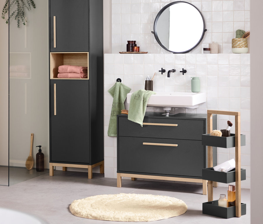 Modernes Badezimmer mit weißer Badewanne, Duschbereich und anthrazitfarbenen Möbeln. Links steht ein Bad-Beistellwagen »Eklund«, rechts ein Bad-Hochschrank »Eklund«, ein Waschbeckenunterschrank »Eklund« mit 2 Schubladen und ein dreistöckiger Beistellwagen.