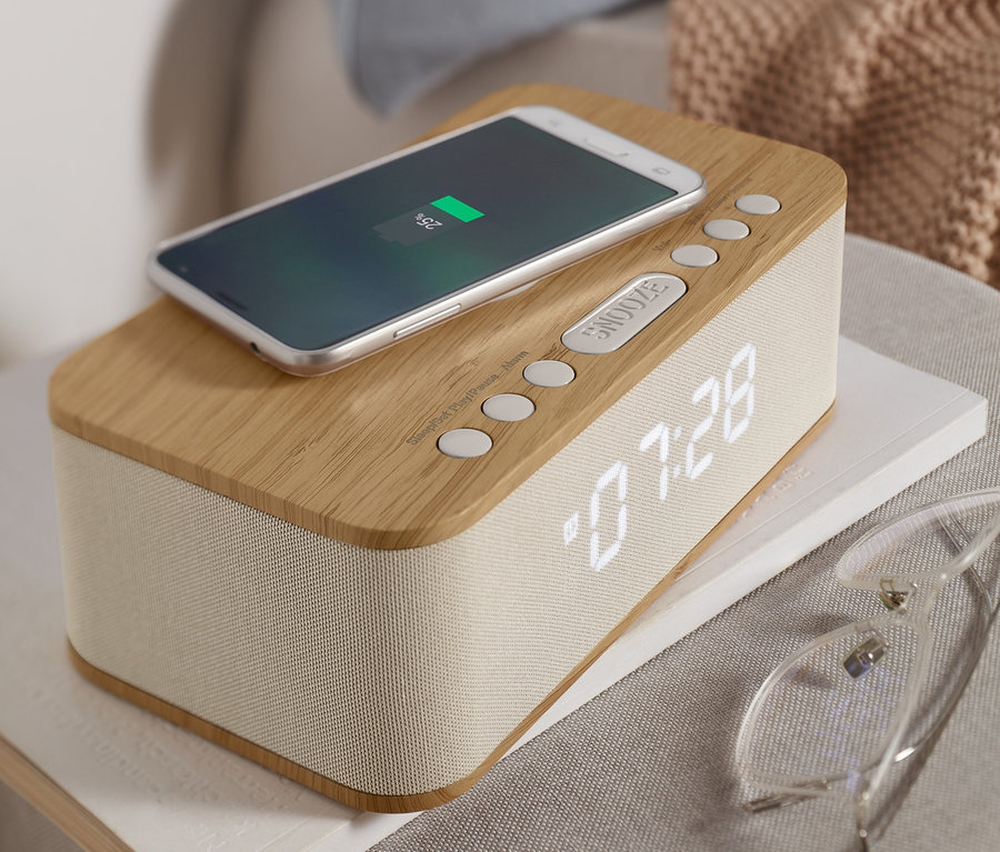 Handy lädt auf Bluetooth-Wecker mit kabelloser Ladefunktion.