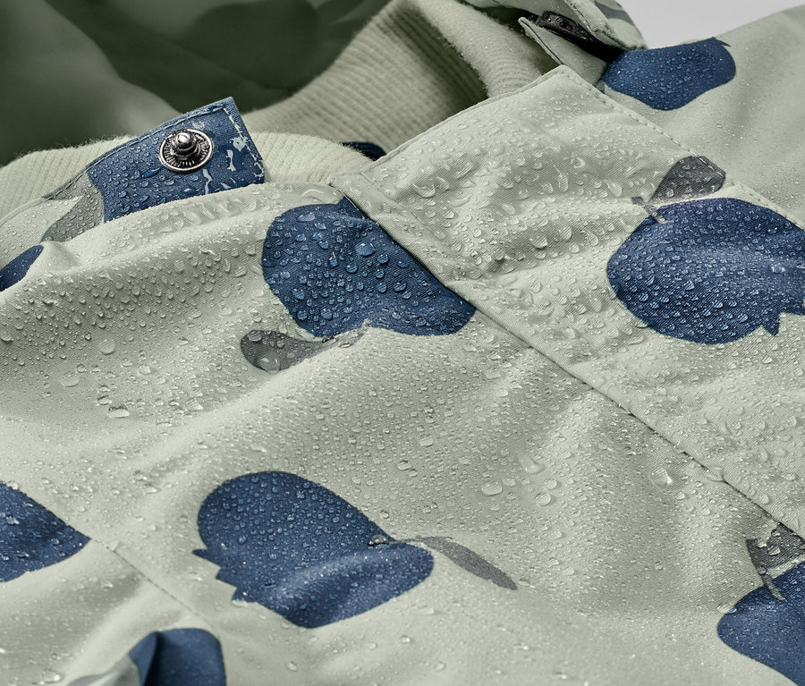 Detailaufnahme eines Kleinkind-Regen-Einteilers mit Wassertropfen und blauem Muster.