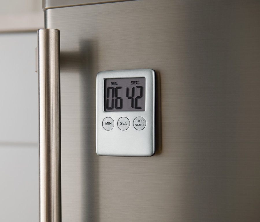 Ein digitaler Kurzzeitmesser ist an einem metallenen Kühlschrank befestigt.