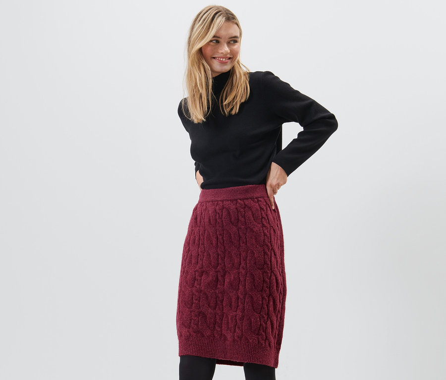 Frau posiert in rotem Strickrock.