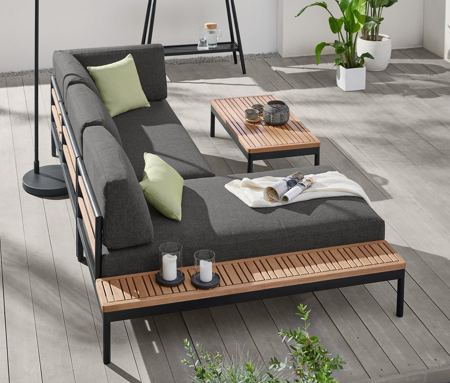 Eine LED-Akku-Bogenleuchte steht neben einer Lounge-Ecke »Elin« mit Premium-Komfort-Kissen. Auf der Lounge-Ecke liegen 2 Premium-Outdoor-Kissen.