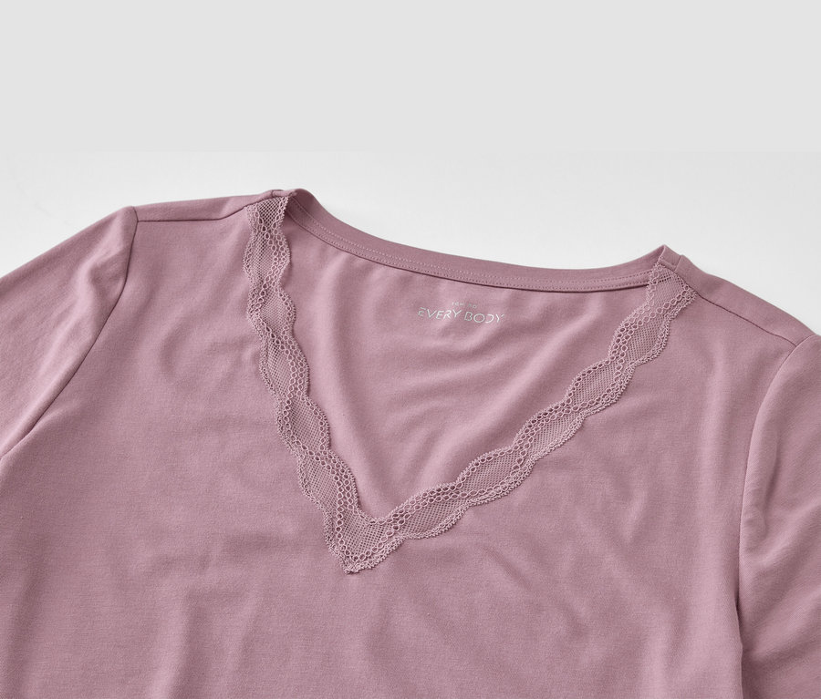 Detail eines lila T-Shirts mit V-Ausschnitt und Spitze.