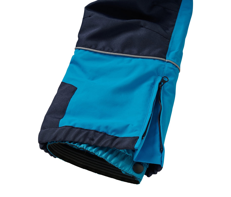 Detail einer blau- und dunkelblauen Skihose mit geöffnetem Reißverschluss an der Seite.