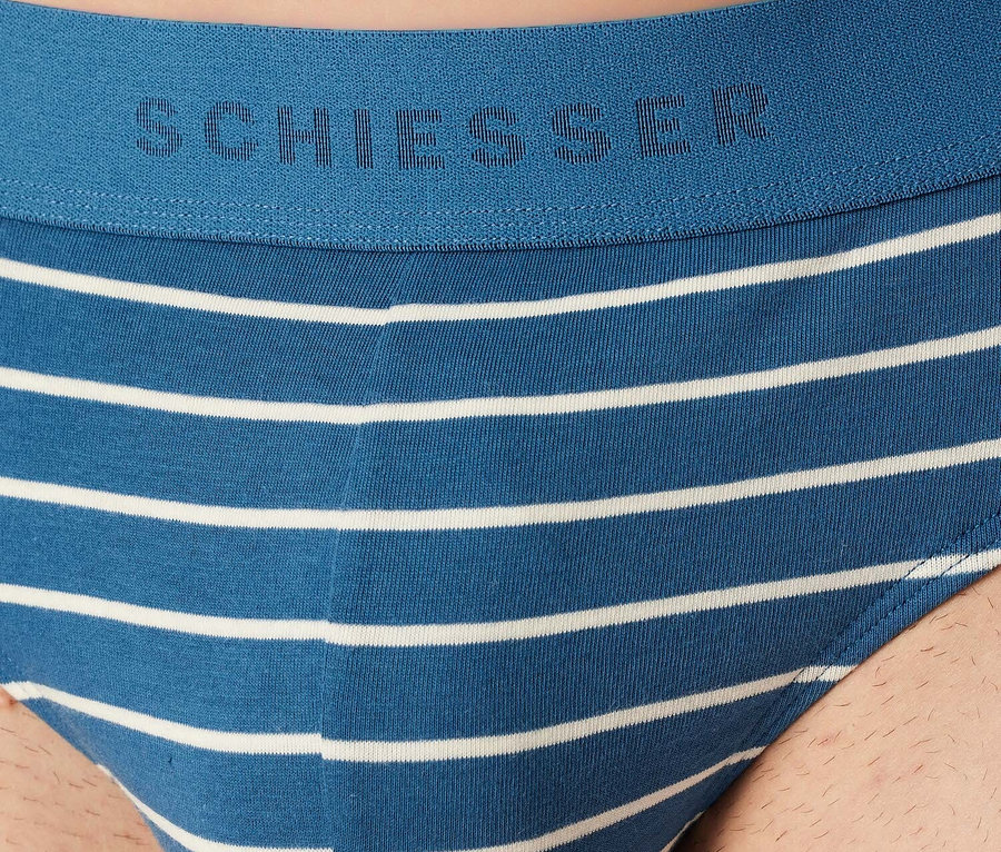 Detailansicht eines blauen Schiesser Herren-Slips mit weißen horizontalen Streifen.