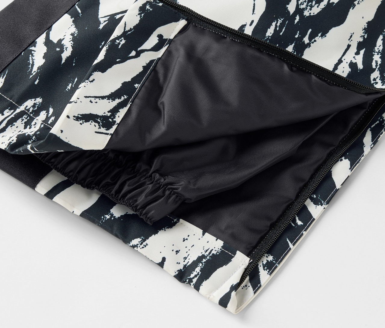 Detailaufnahme einer schwarz-weiß gemusterten Hose mit offener Tasche.