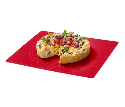 Ein Kuchen mit Früchten auf einer roten Dauerbackmatte.