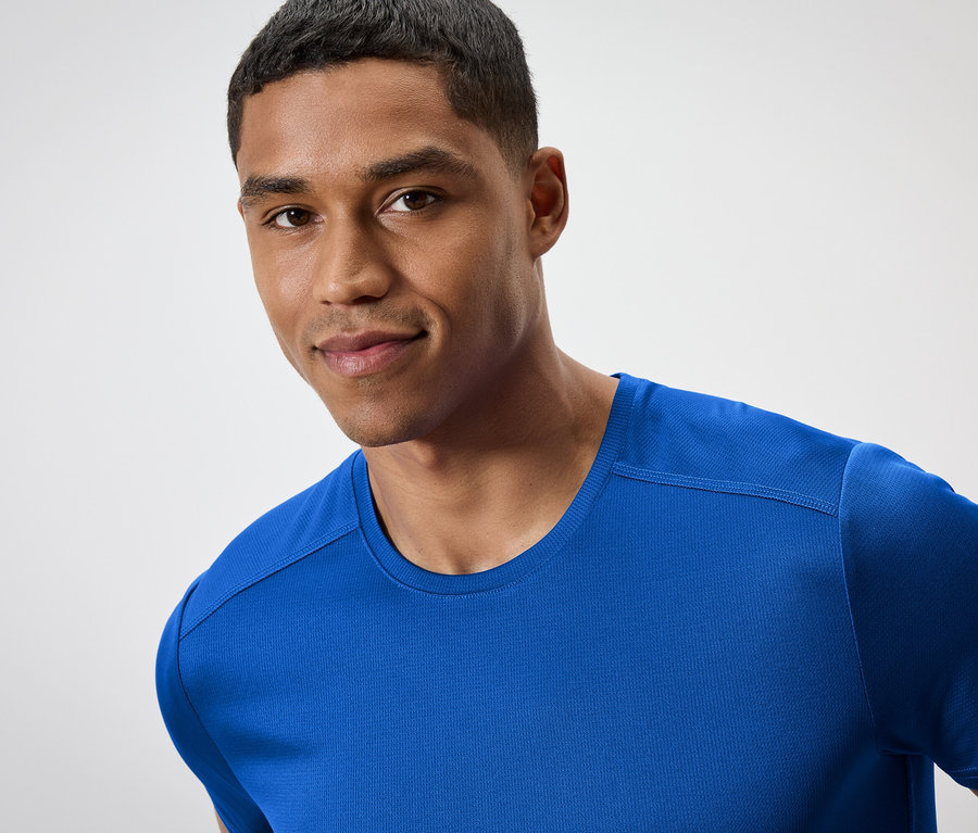 Porträt eines lächelnden Mannes in einem blauen T-Shirt.