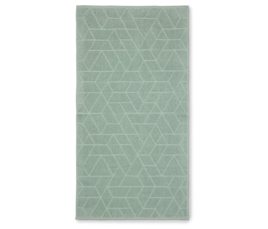 Ein hellgrünes Handtuch mit geometrischem Muster liegt flach auf einer weißen Oberfläche.